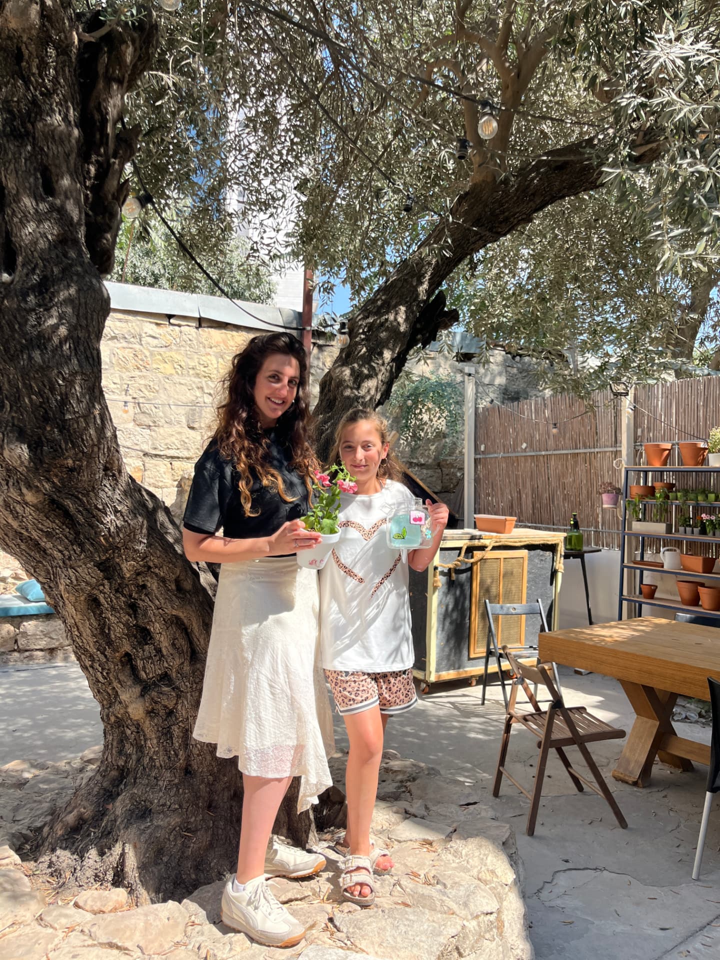 משתתפות בחצר הסטודיו עם עציץ וקנקן זכוכית מצוירים