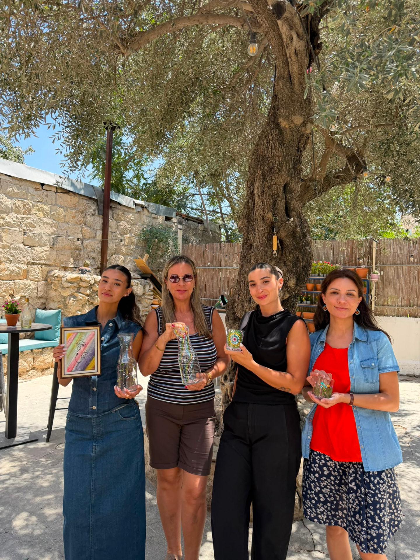 משתתפות בחצר עם כלי זכוכית מצוירים בעבודת יד