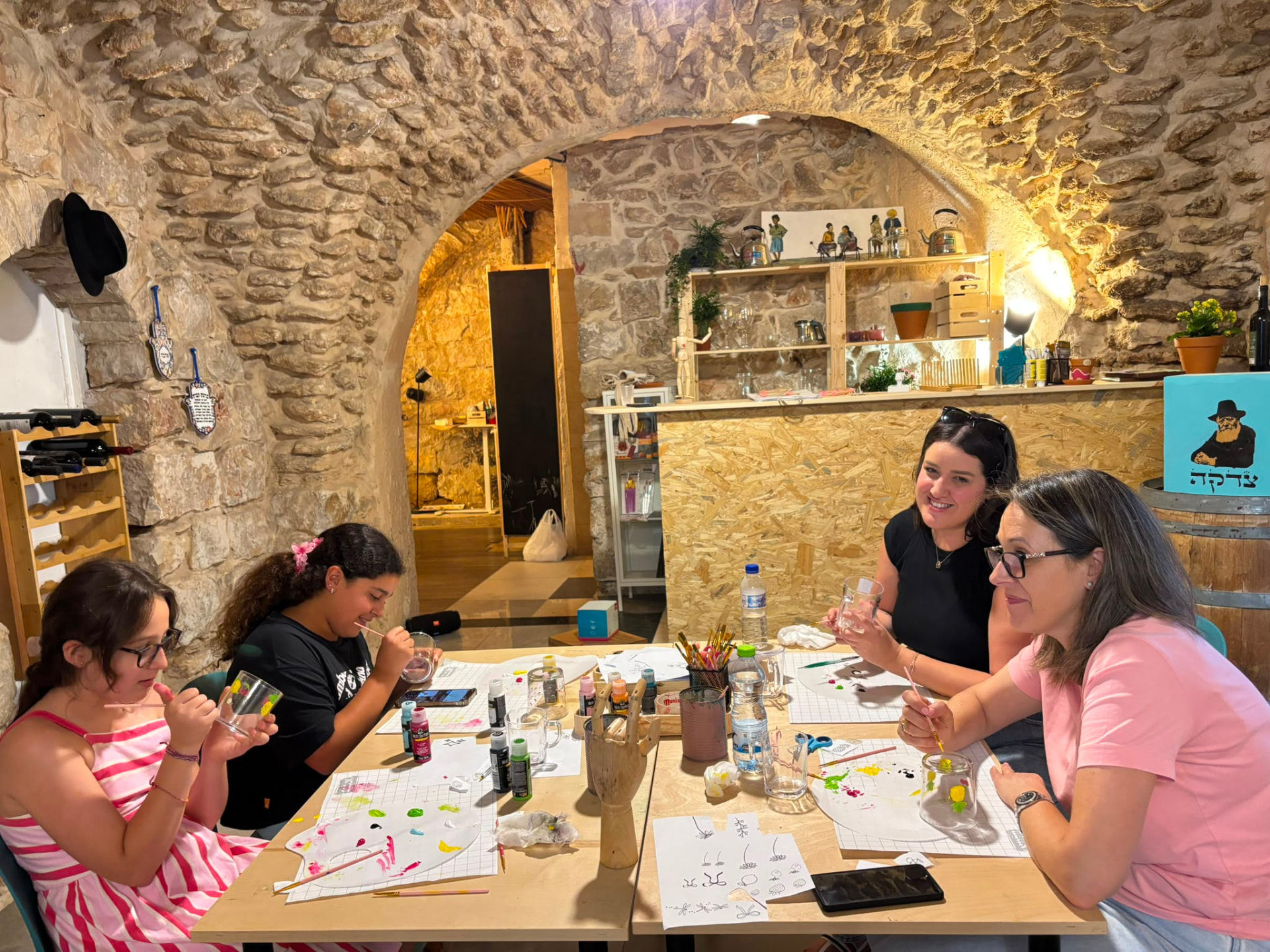 יוצרים סביב שולחן העבודה במרתף האבן של הסטודיו