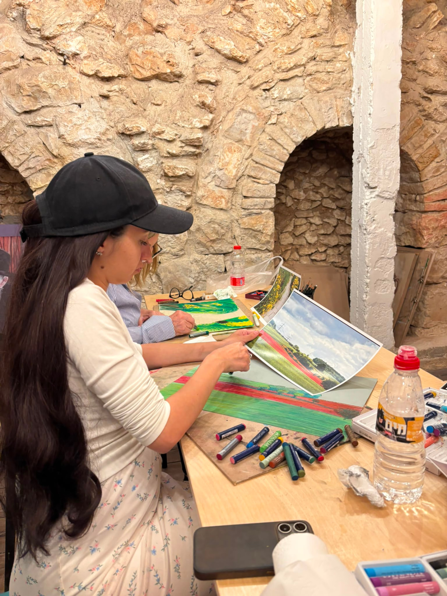 משתתפת מציירת נוף בפסטל בסדנת ציור